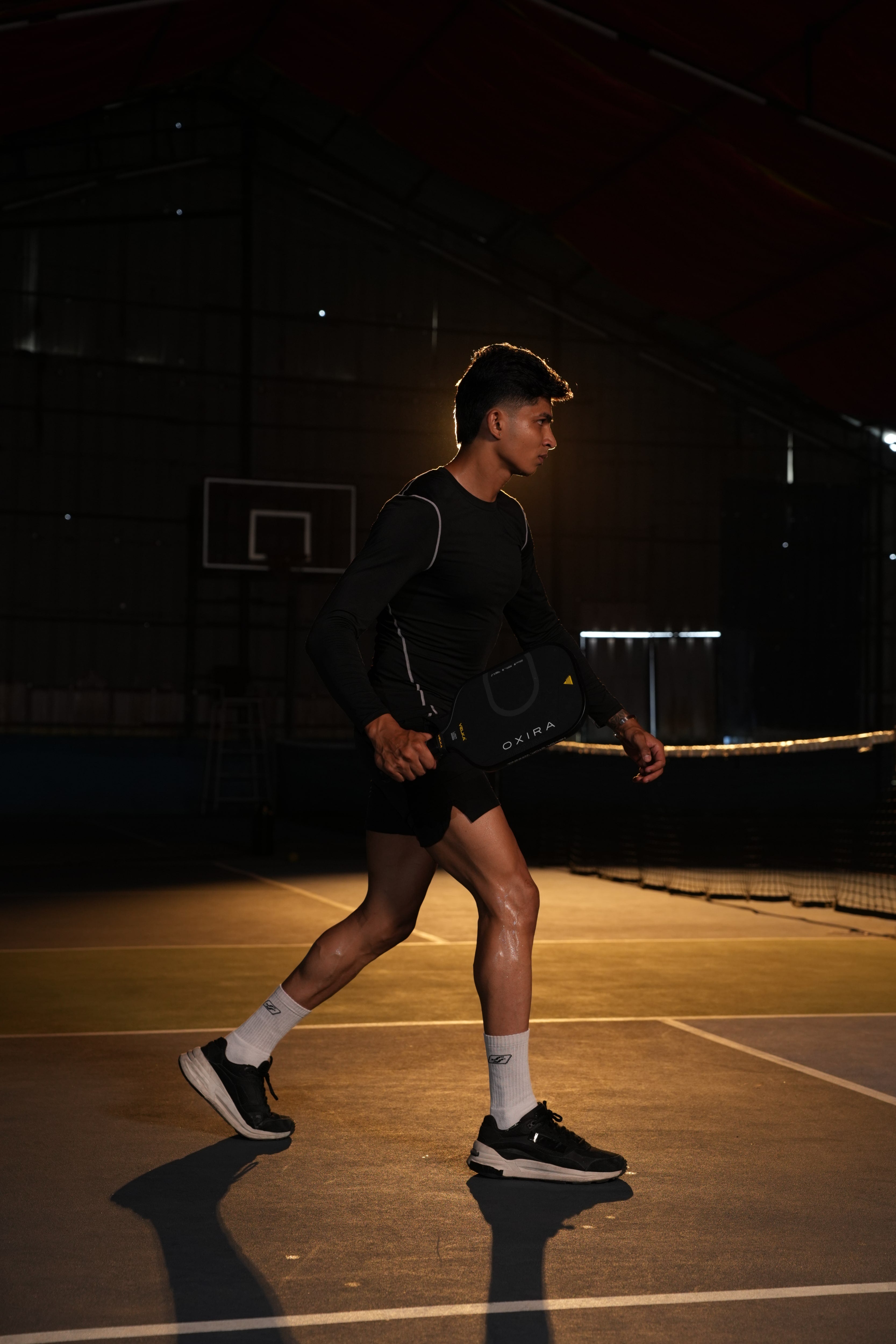 An athlete playing with Velka's Oxira Pickleball paddle on a Pickleball Court.